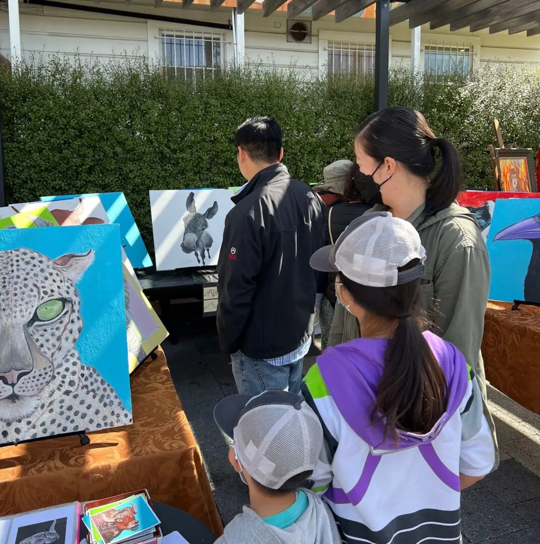 adults and kids looking at the paintings